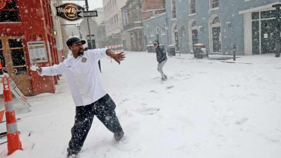 Sous chef Eric Walker engages in a snowball fight outside the Bourbon House Restaurant in the French Quarter in New Orleans, Louisiana, where a rare snow storm hammered the southern US city