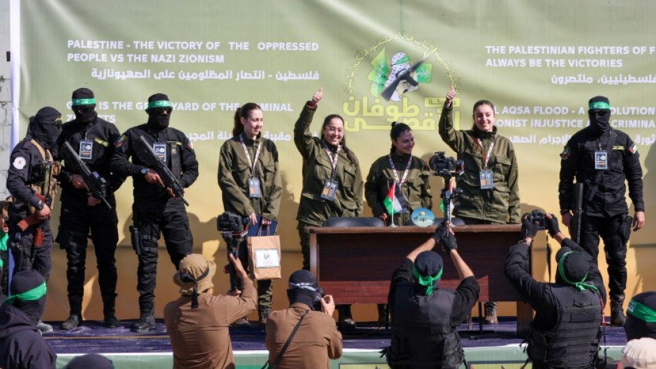 The four Israeli hostages, all soldiers, emerged to whistles, cheers and shouts from the crowd as Hamas camera crews and photographers swarmed around them.