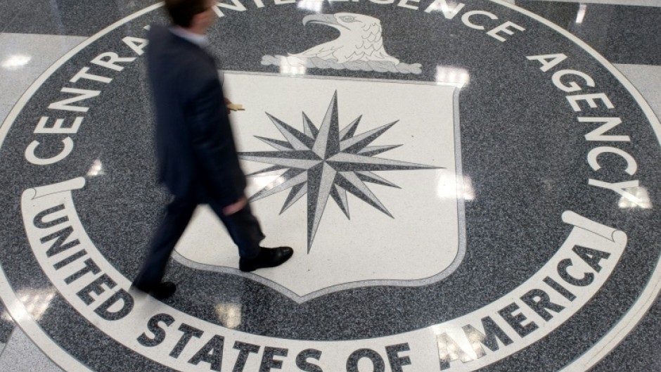 A man crosses the Central Intelligence Agency (CIA) seal in the lobby of CIA Headquarters in Langley, Virginia in August 2008