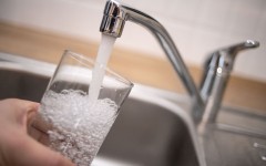 File: A man holds a glass under a running tap. AFP/DPA/Marius Becker