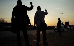 File: Commuters hold up their hands to signal to oncoming taxis what their desired destination is. Morne De Klerk/Getty Images