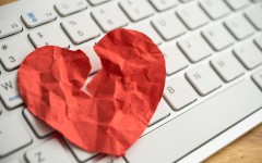 File: A broken heart paper on white keyboard computer background. GettyImages/Pla2na