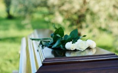 File: A bunch of roses on top of a coffin. GettyImages/shironosov