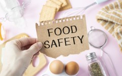 File: A person holds a card with the text FOOD SAFETY. GettyImages/Inna Kot