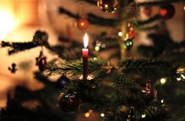 A candle burns in a living room on a festively decorated Christmas tree. Karl-Josef Hildenbrand/dpa/AFP