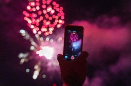 A person filming fireworks.