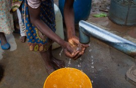 File: A woman washes her hands and drinks water from a borehole. Getty Images/Guido Dingemans/De Eindredactie