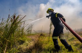 File: Firefighters try to extinguish a veld fire. Jaco Marais/Die Burger/Gallo Images via Getty Images