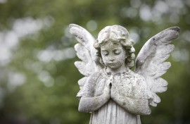 Stone cherub praying in graveyard. GettyImages/richardwatson