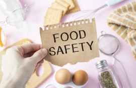 File: A person holds a card with the text FOOD SAFETY. GettyImages/Inna Kot