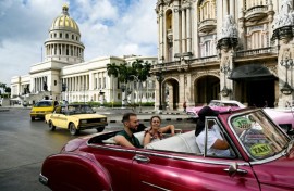 Tourists ride in a classic American car through the streets of Havana 