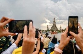 Spectators watch the Royal Barge Procession on the Chao Praya River