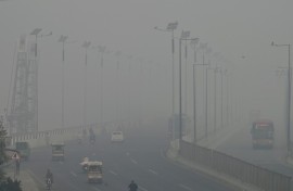 Commuters drive along a road amid heavy smog in Lahore