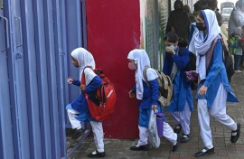 Students wearing masks arrive for classes as schools reopened amid smoggy conditions in Lahore on Wednesday