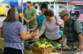 People shop for fresh produce and food at a farmer's market on June 29, 2021, in Homewood, Alabama