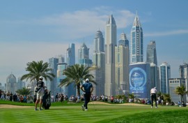 Northern Ireland's Rory McIlroy (R) putts on the eighth hole during the first day of the Dubai Desert Classic