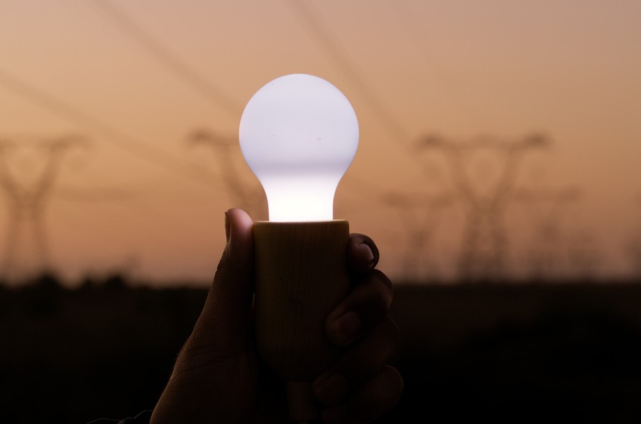 File: A person holds a lightbulb with electricity cables for supply of power. Getty Images/Sean Anthony Eddy