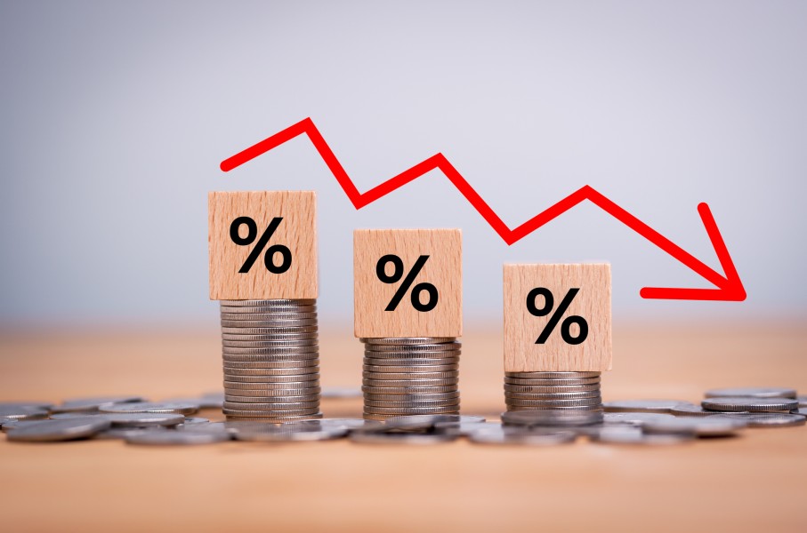 File: A percentage sign on coins indicating a downwards trend of inflation. Getty Images/Mongkol Onnuan