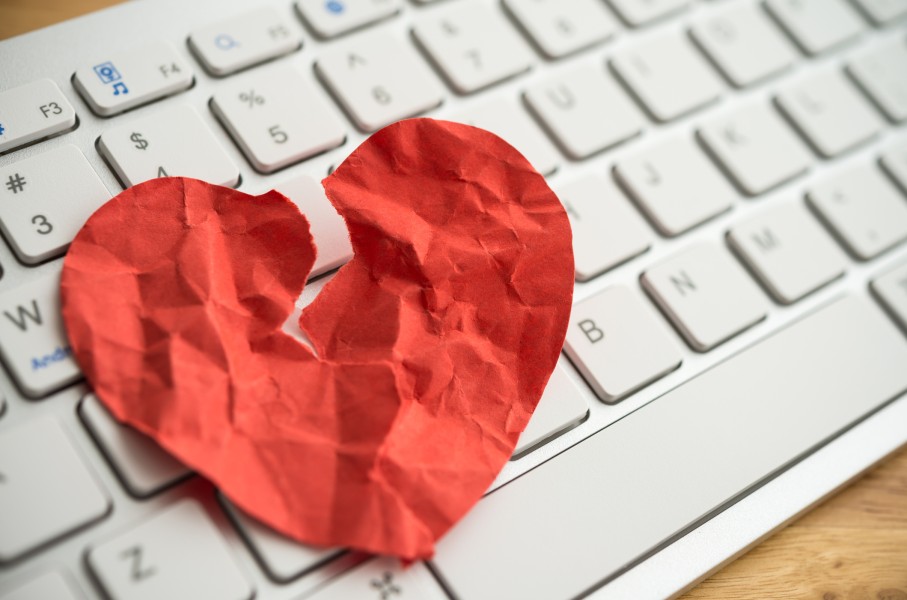 File: A broken heart paper on white keyboard computer background. GettyImages/Pla2na