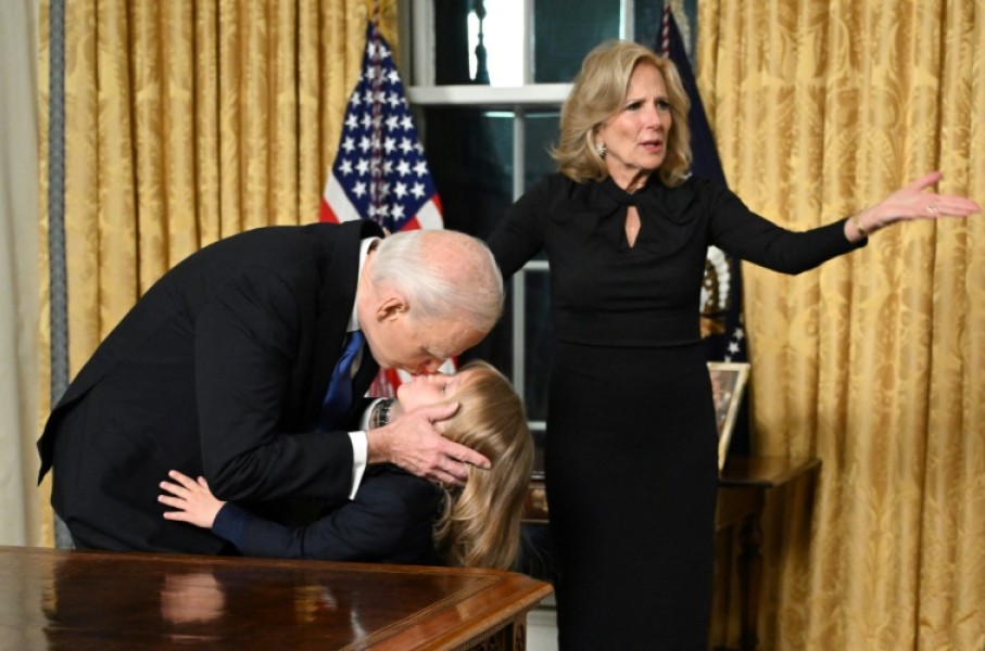 US President Joe Biden kisses his grand-son Beau Biden Jr. as First Lady Jill Biden gestures after the President delivered his farewell address to the nation from the Oval Office of the White House in Washington, DC, on January 15, 2025.