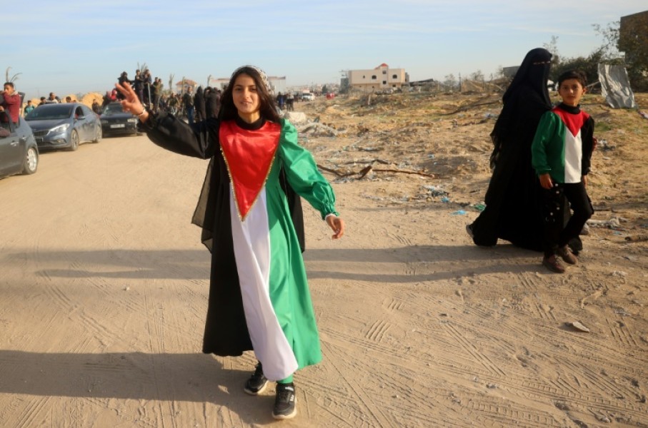 A young woman wears a dress in the colours of the Palestinian flag, celebrating the ceasefire