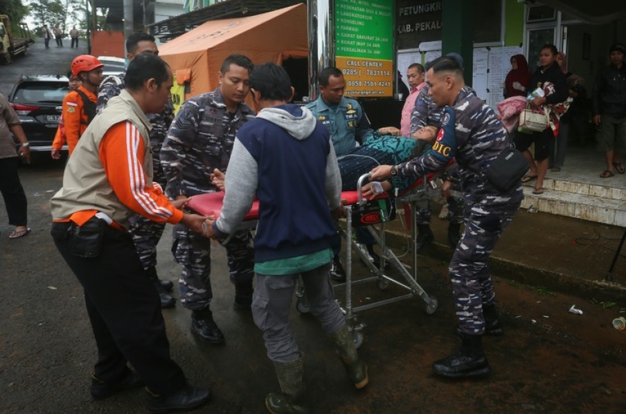 A survivor is brought to an Indonesian hospital from the site of a landslide triggered by heavy rain