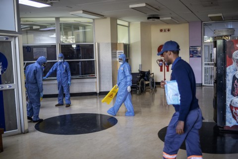 Workers wearing protective clothing clean an entrance hall of the Charlotte Maxeke Hospital in Johannesburg.