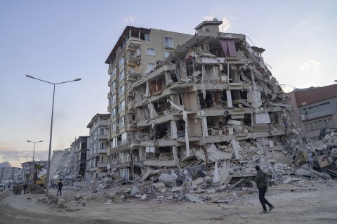 File: A man looks up at a collapsed building in Hatay, southern Türkiye on February 19, 2023. Yasin AKGUL / AFP