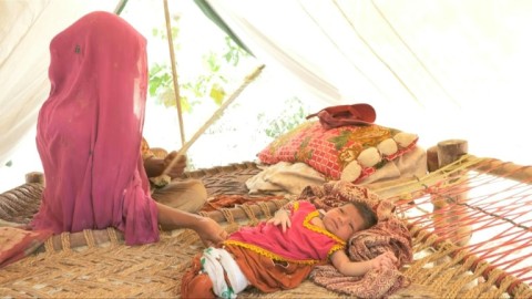 After the flood, mother and child return to drowned Pakistan village