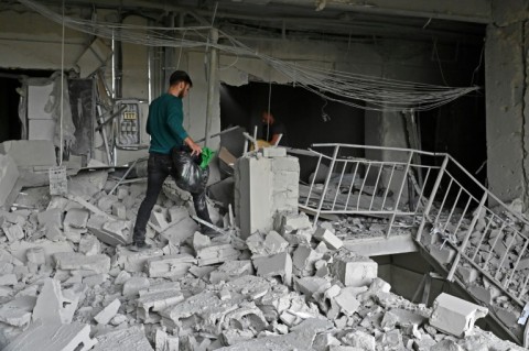 Local residents carry out their belongings from a building partially destroyed by a missile strike in Kharkiv 