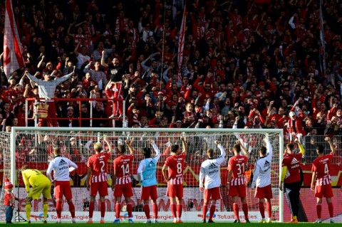 Union Berlin players celebrate with their fans after beating Wolfsburg to stay top of the Bundesliga 