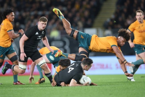 New Zealand's Will Jordan is tackled as Australia's Rob Valentini dives over the top during the rugby test match at Eden Park in Auckland