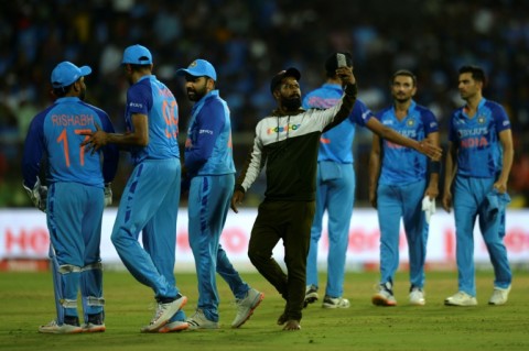 Unwanted intrusion: A pitch invader takes a selfie with India players 