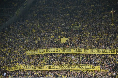 Dortmund fans hold a banner reading 'Police Do(rtmund) - killing two more times and then it will be Christmas - For an independent police complaints office' on Saturday. 