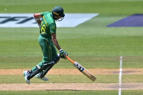 The Netherlands' Tom Cooper plays a shot over the boundary line for six runs watched by South Africa's wicketkeeper Quinton de Kock (L) during their men's Twenty20 World Cup match