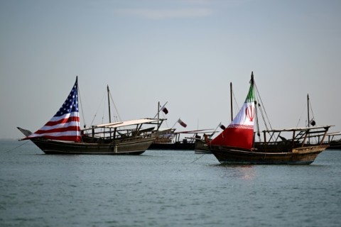 Traditional Qatari dhow boats fly the US and Iranian flags off the coast of Doha