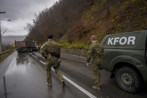 NATO soldiers in the Kosovo peacekeeping mission (KFOR) inspect a road barricade set up by ethnic Serbs