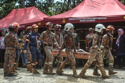 Rescue workers scoured muddy terrain for survivors and bodies as the death toll from a landslide at a Malaysian campsite rose to 24