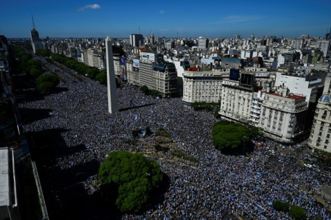 Vast crowds wait for the Argentina players' bus parade in central Buenos Aires to celebrate after winning the Qatar 2022 World Cup