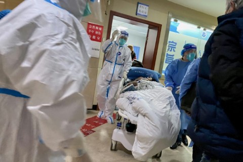 Health workers transport a Covid patient through the Chongqing No. 5 People's Hospital