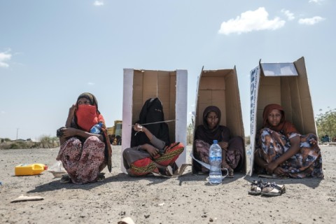 Women take shelter in cardboard boxes as they wait to be registered as displaced in Semera, Afar region, in February