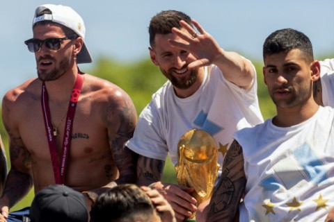 Lionel Messi (centre) celebrates Argentina's World Cup victory alongside team-mates Rodrigo de Paul (left) and Cristian Romero (right) in Buenos Aires before Christmas