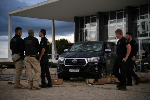 Police officers inspect damage outside the Supreme Court building in Brasilia after thousands of supporters of Brazil's far-right ex-president Jair Bolsonaro raided the seats of government