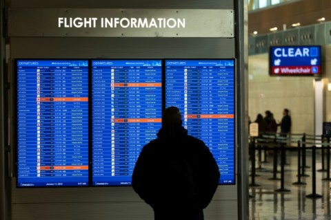 A traveler looks at a display listing cancelled and delayed flights at Ronald Reagan National Airport in Virginia on January 11, 2023