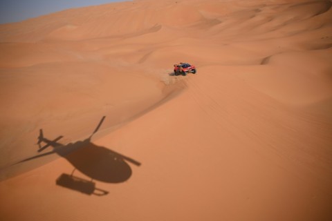 Sebastien Loeb and Belgian co-driver Fabian Lurquin steer their BRX to victory tracked by a helicopter in Saudi Arabia's Empty Quarter