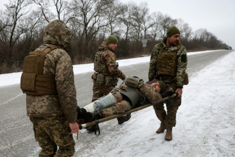 Ukraine army medics evacuate a wounded soldier on a road not far of Soledar on Saturday