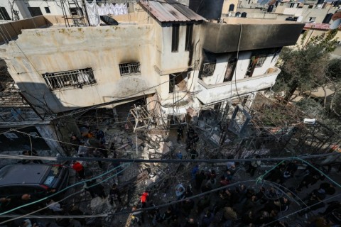 A Palestinian man mourns the death one of those killed during the raid as residents began the funeral processions