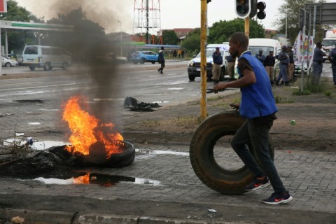 Anger: A resident prepares to throw a tyre on a street barricade in Soshanguve township, north of Pretoria, in a protest on Wednesday about water and power cuts