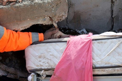 A survivor reacts as rescuers work in the quake-hit Turkish city Hatay