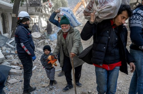 Rescuers carry out search operations among the rubble of collapsed buildings in Adiyaman, Turkey